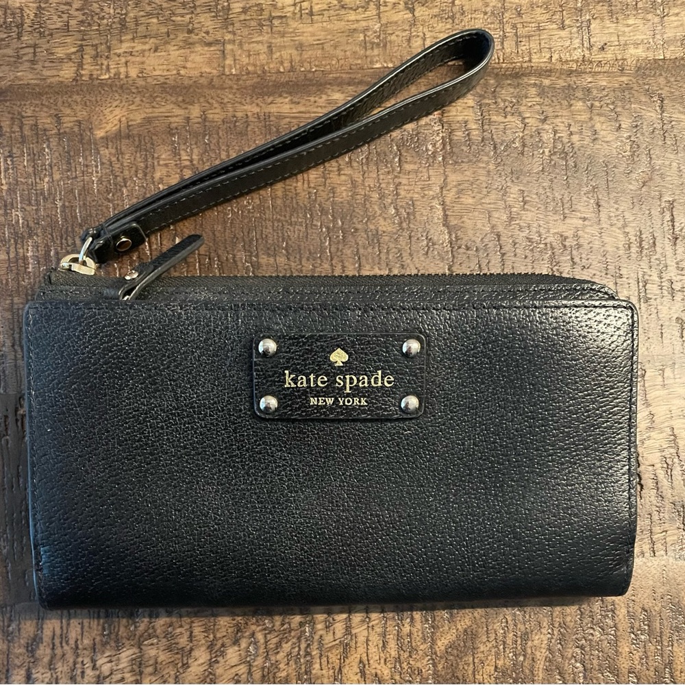 Kate Spade black leather wallet with nude interior trim and bright pink lining.